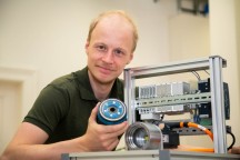 TU Graz promovendus Philipp Eisele met een kunststof  model op ware grootte  en het prototype van de Smart Gear in de testopstelling: De productie van de nulserie is gepland voor dit jaar. (Foto: Frankl - TU Graz)'