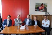 Tobias Daniel (tweede van links) en Michiel Brink (derde van links) schudden elkaar de hand bij het distributeurscontract. (Foto: Robotics Benelux)'
